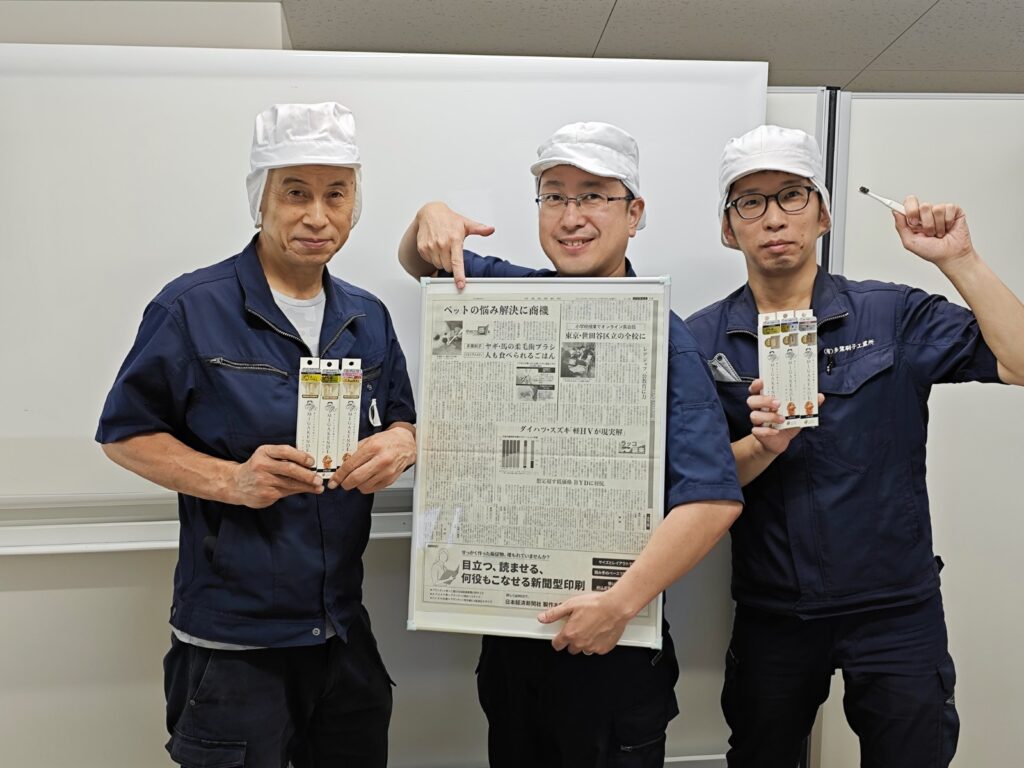 日経新聞掲載の紙面と自社製品を持つ多葉ブラシ工業所のスタッフ3名